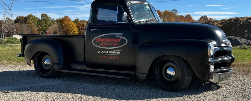 Black Checkered Racing Chevy truck parked outdoors